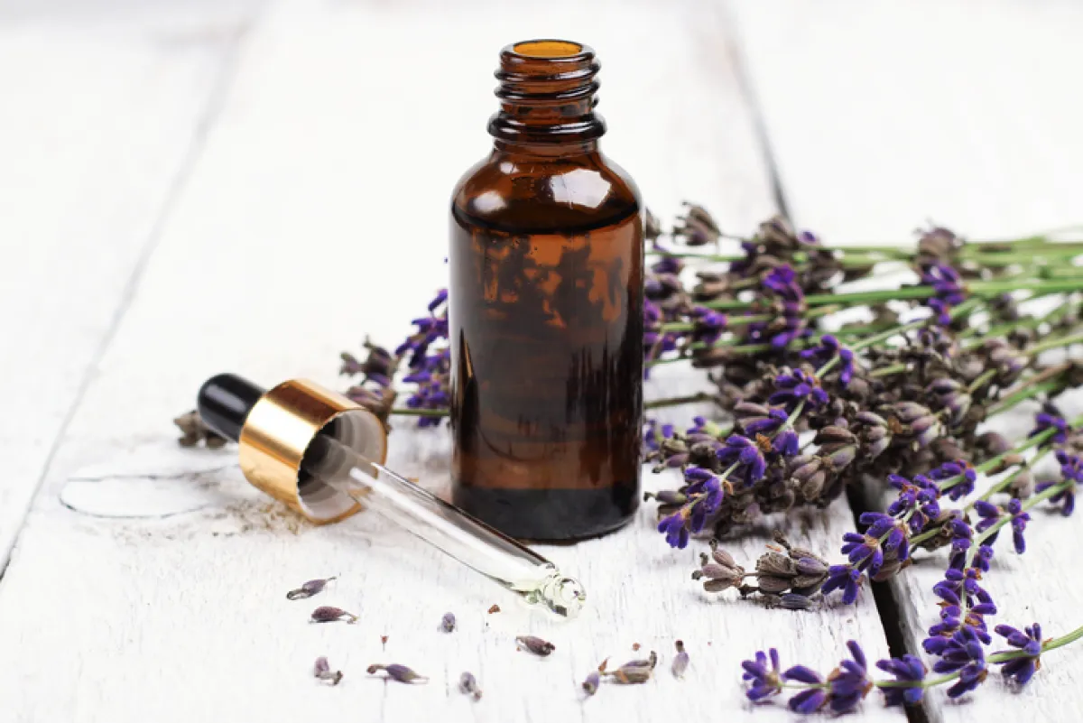 Aceite natural de lavanda sobre una mesa de madera blanca.