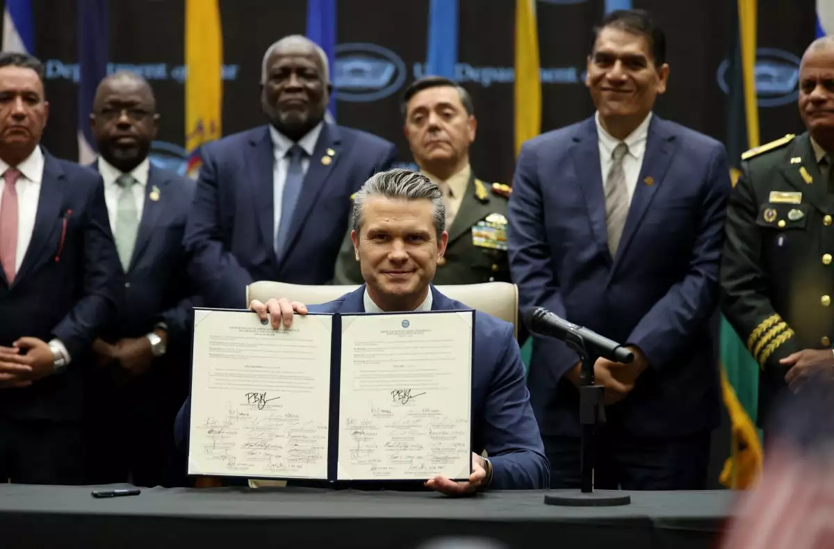 El Secretario de Defensa, Pete Hegseth, celebra una Declaración de Seguridad Conjunta de la Conferencia Contracártel de las Américas después de firmarla mientras los líderes regionales de defensa y seguridad del Caribe y América Central y del Sur lo respaldan durante la Conferencia inaugural contra el Cártel de las Américas en la Sede del Comando Sur de los Estados Unidos el 5 de marzo de 2026 en Doral, Florida.