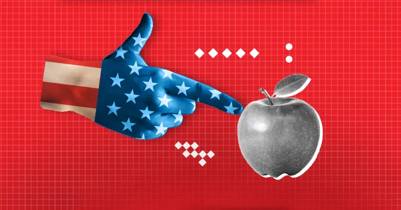 Una mano pintada como la bandera de Estados Unidos apunta a una manzana. 