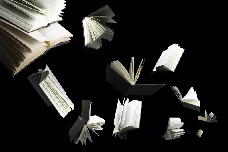 Flying several books isolated on black background.