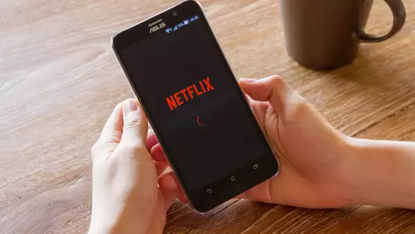 La suscripción de Netflix con anuncios está más cerca. (Unas manos sosteniendo un smartphone en el que se ve el logo de Netflix). 