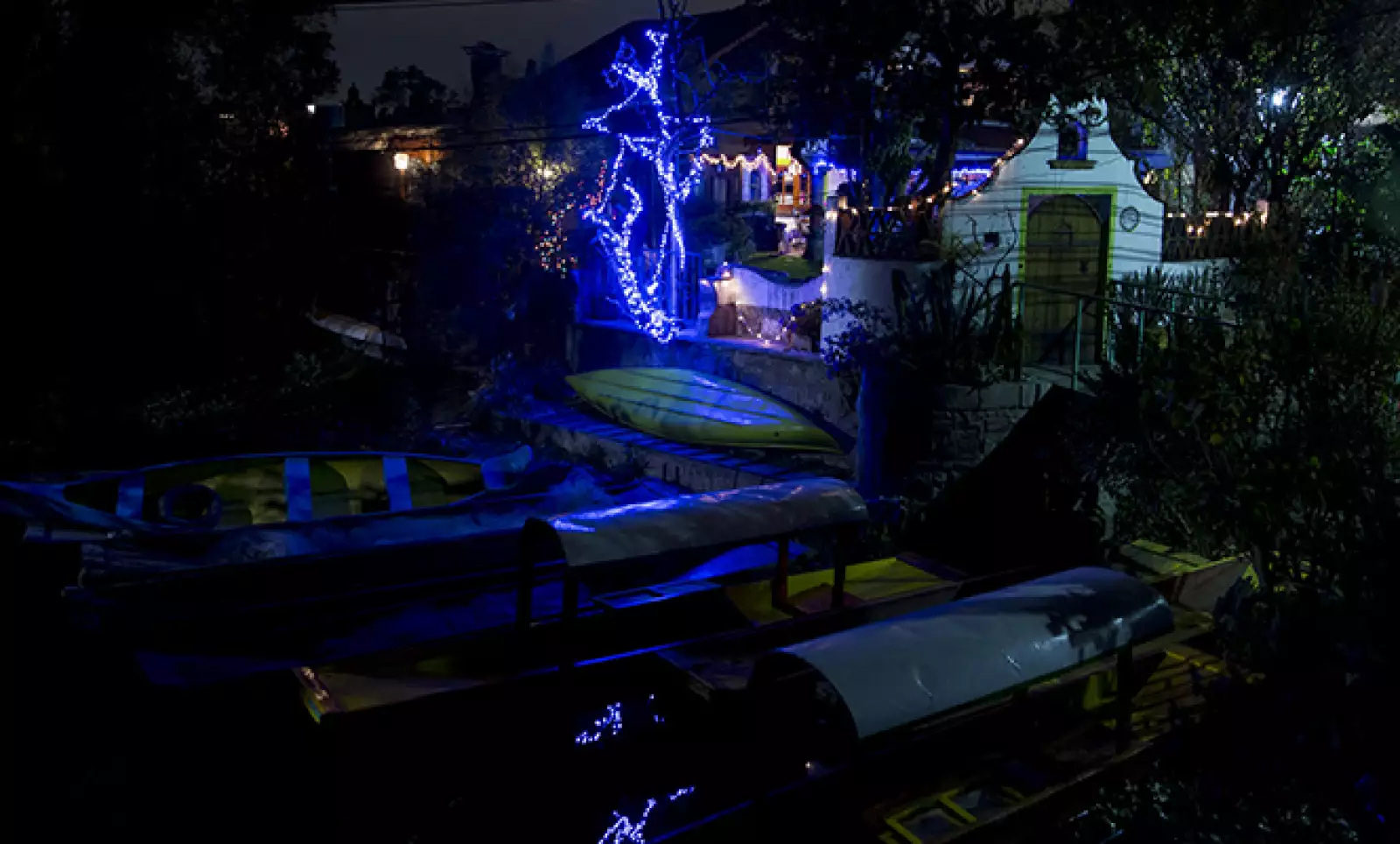 Las luces alumbran a algunas trajineras en las orillas del Lago de Xochimilco.