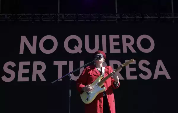 Foto de la cantante mexicana Ruzzi cantando y con una guitarra en mano