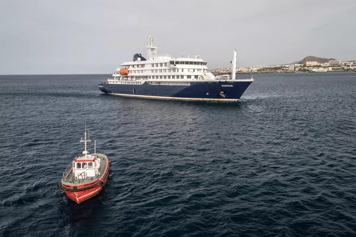 Esta vista aérea muestra un barco que se dirige hacia el puerto desde el crucero MV Hondius, estacionario fuera del puerto de Praia, la capital de Cabo Verde, el 6 de mayo de 2026.