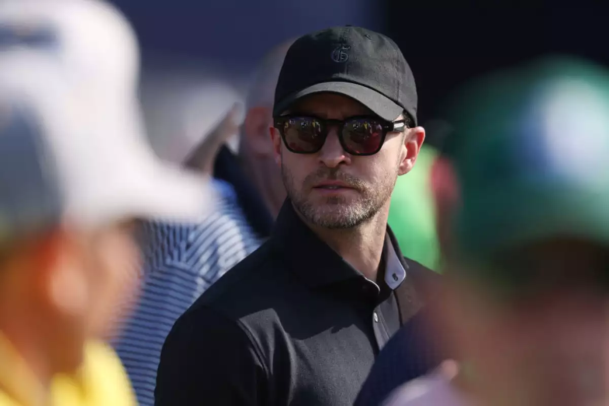 foto de archivo de justin timberlake vistiendo una playera tipo polo negra, con lentes oscuros y gorra negra.