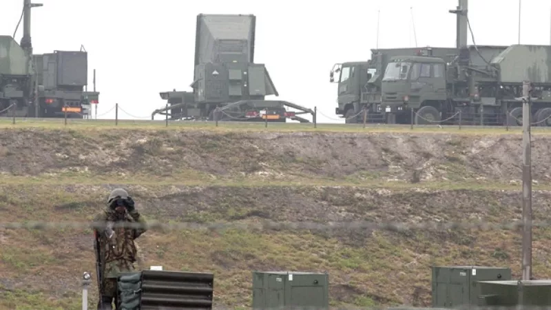 un soldado japones hace guardia ante un sistema de defensa