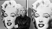 Andy Warhol frente a una de sus obras icónicas del arte pop.