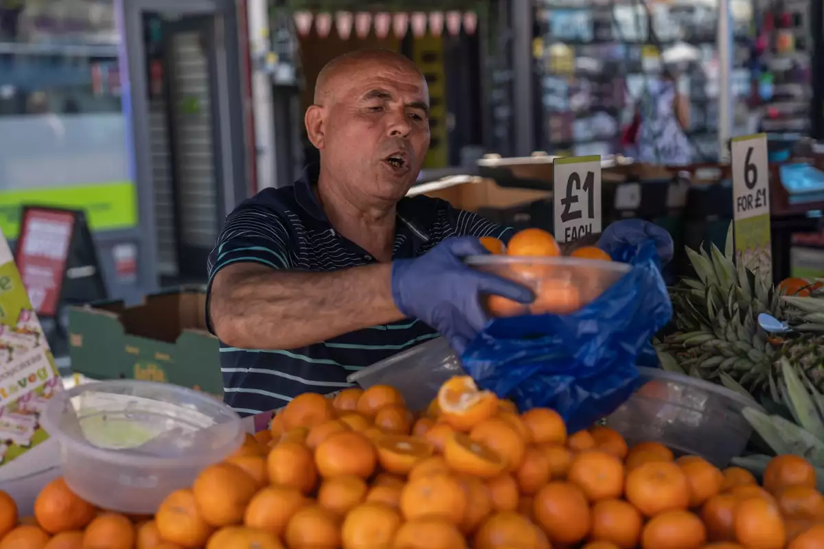 (Un comerciante vende naranjas en un mercado callejero de Londres)