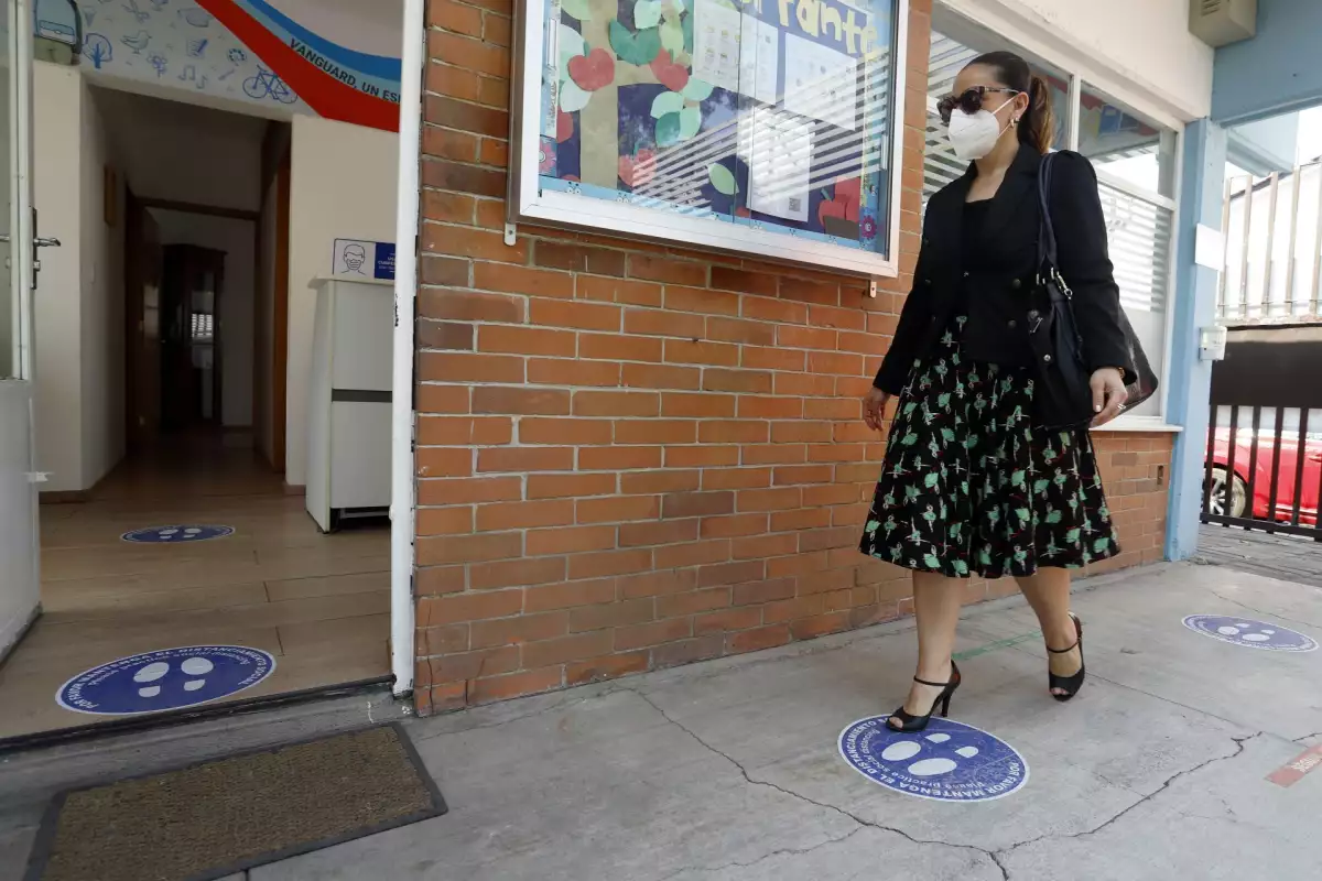 El regreso a clases presenciales en México se puede hacer. Maestra entrando a un salón de clases. 