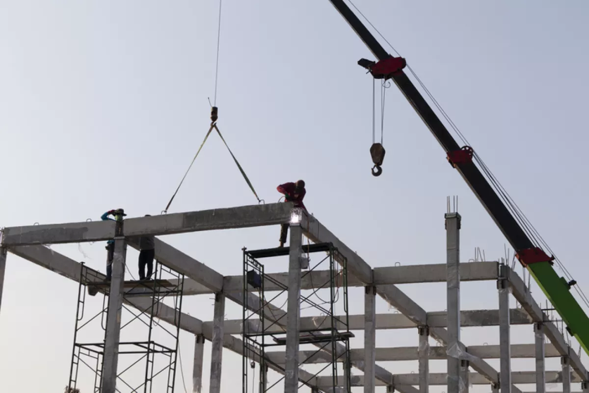precast concrete beam installed at construction site by mobile crane
