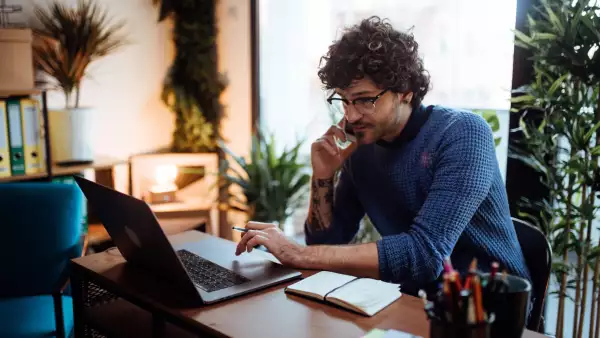 Young man talking on the phone in his home office