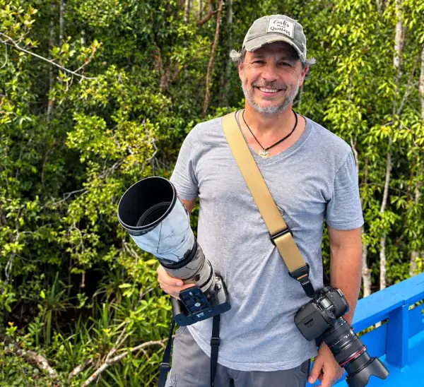 Gerardo del Villar, fotógrafo y documentalista mexicano, posa con equipo fotográfico frente a la selva de Borneo durante su expedición para documentar orangutanes.