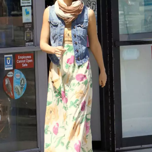 Jessica Alba combina la prenda con un maxivestido a flores y una foulard.