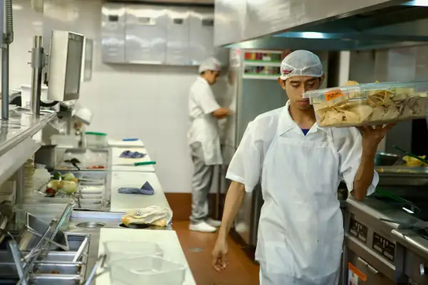Trabajador de un restaurante camina con alimentos.