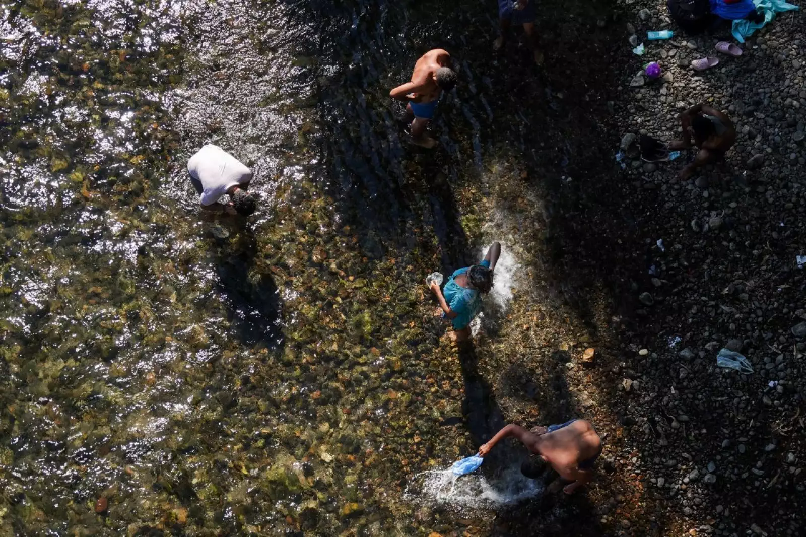 Migrantes toman un baño en el Río Ostuta previo a continuar su recorrido a Santiago Niltepec.