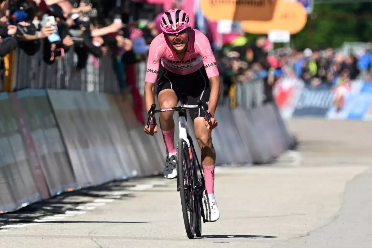 Foto de Isaac del Toro a bordo de su bicicleta sin nadie detrás de él y usando la camiseta rosa de líder de la carrera Giro de Italia.