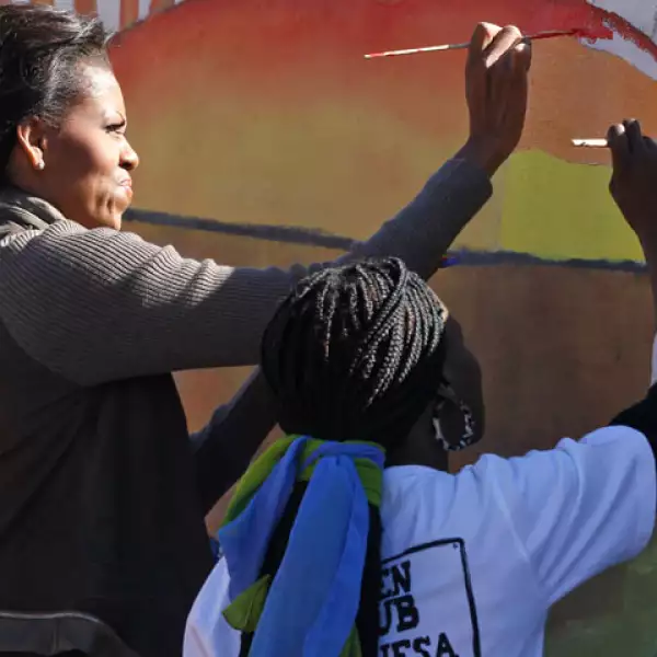 Michelle e integrantes de su familia que la acompañan ayudaron a pintar un mural en la pared de una nueva instalación que se está construyendo en Botsuana.