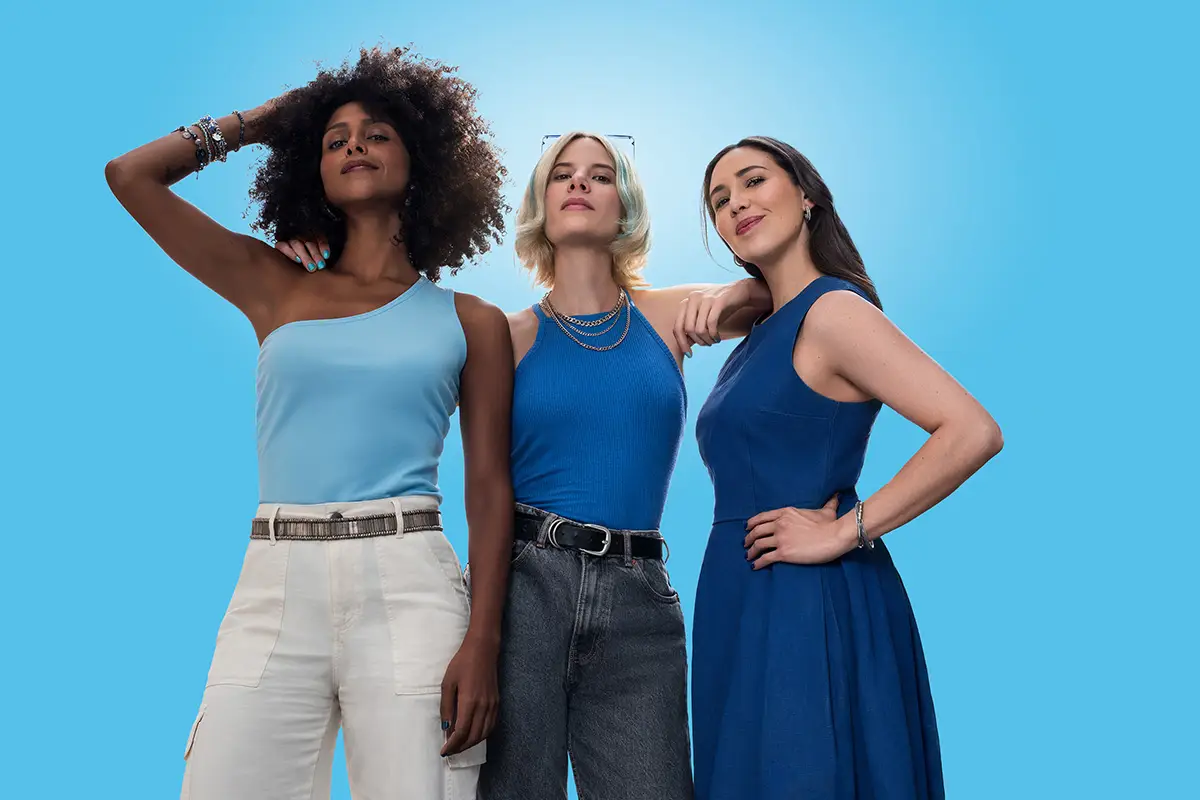 Tres mujeres abrazadas con actitud empoderada