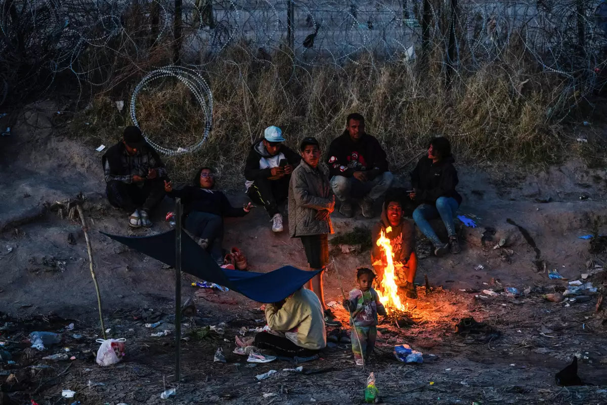 Un grupo de migrantes acampa a lo largo del muro fronterizo en el lado estadounidense del Río Grande después de los Estados Unidos. 