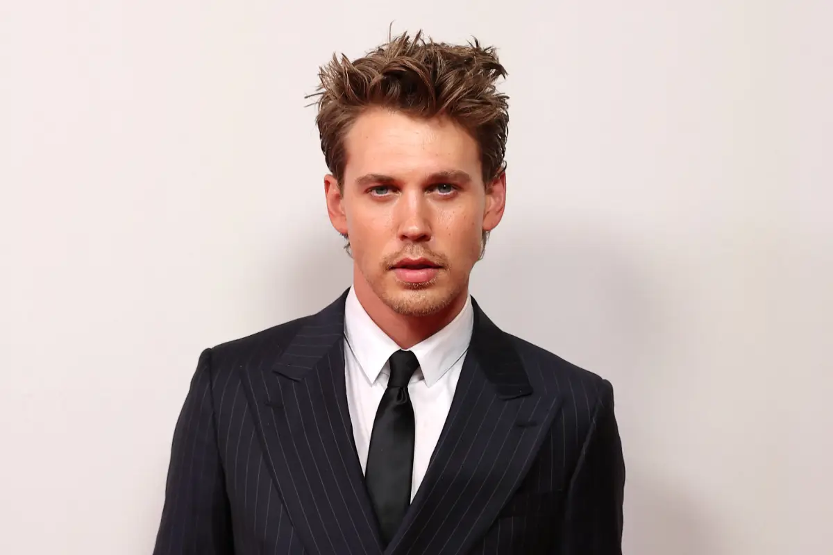 Foto de Austin Butler vestido de traje negro y corbata.