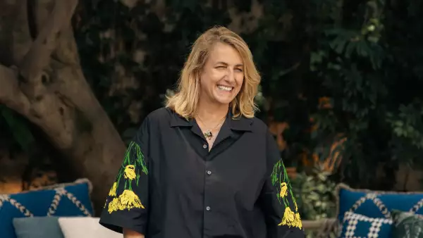 Foto de la arquitecta Patricia Urquiola con camisa over sized negra con mangas de flores amarillas.