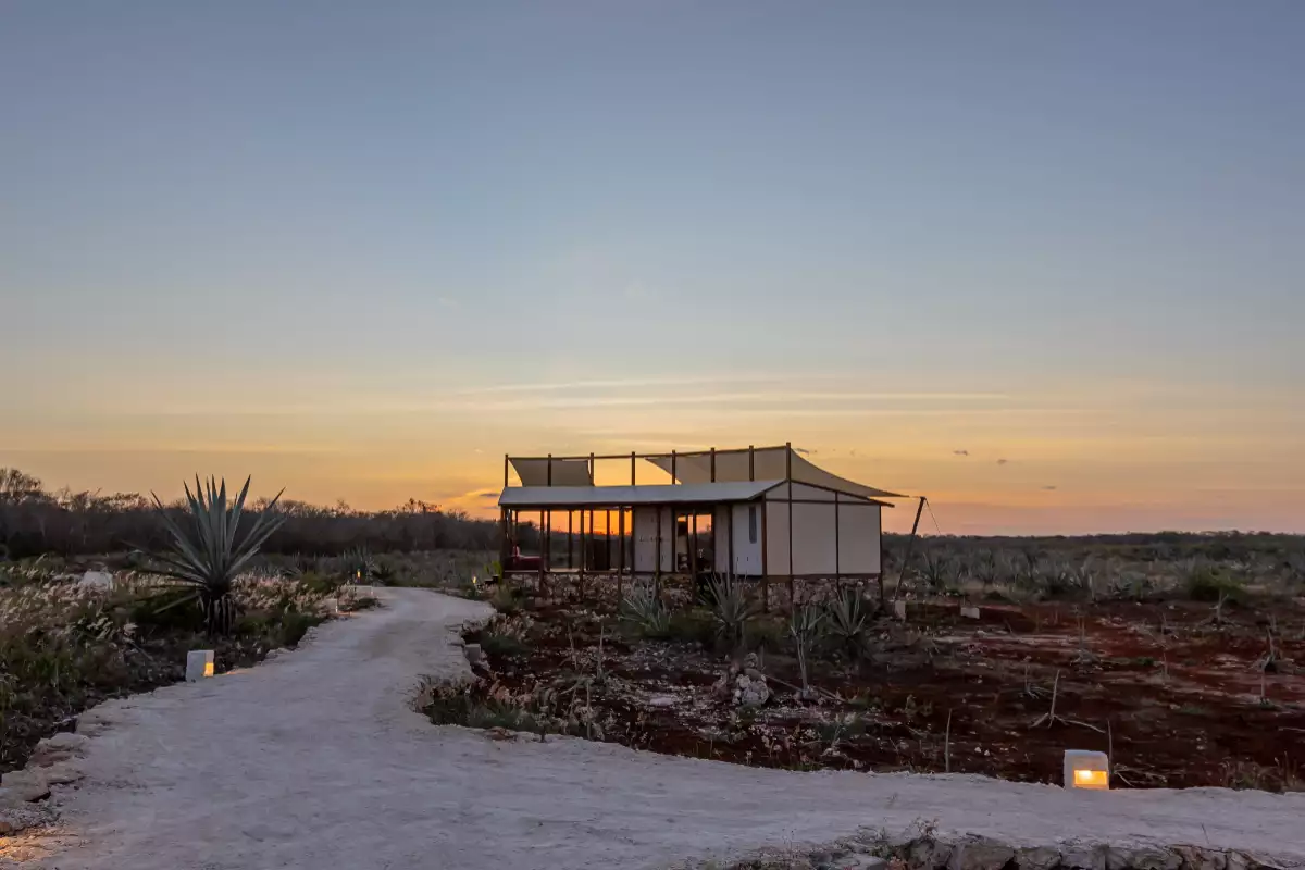 foto de un atardecer en la hacienda xtojil, en merida, en el que se ve una de las cabañas del glamping.