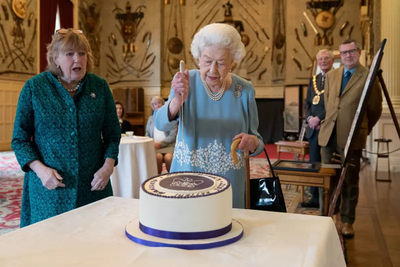 La reina Isabel II de Inglaterra corta su pastel para celebrar el inicio de su Jubileo de Platino durante una recepción en el salón de Sandringham House. 