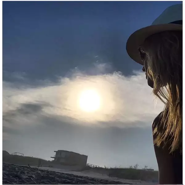 Heidi Klum con un pánama hat disfrutando del atardecer.