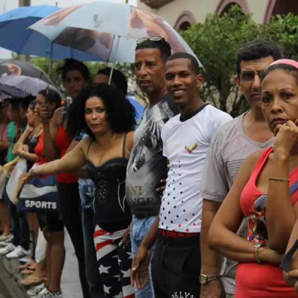 Decenas de cubanos desafiaron las inclemencias del clima y aguardaron el paso de la caravana presidencial en su camino hacia La Habana Vieja