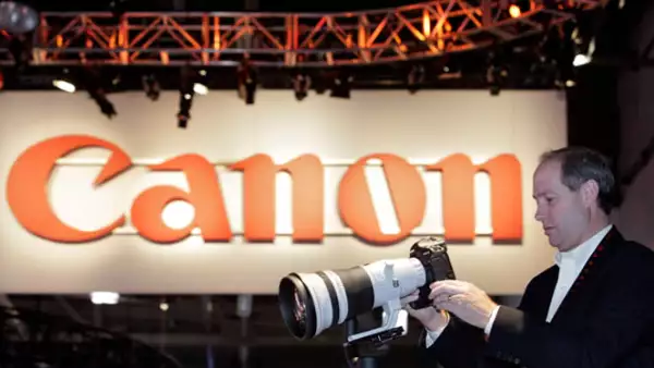 Un fotógrafo profesional visita el ‘stand’ de Canon, para apreciar su nueva cámara y telefoto de 400mm.