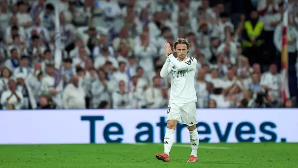Foto de Luka Modric aplaudiendo en el campo de juego con el uniforme del Real Madrid.