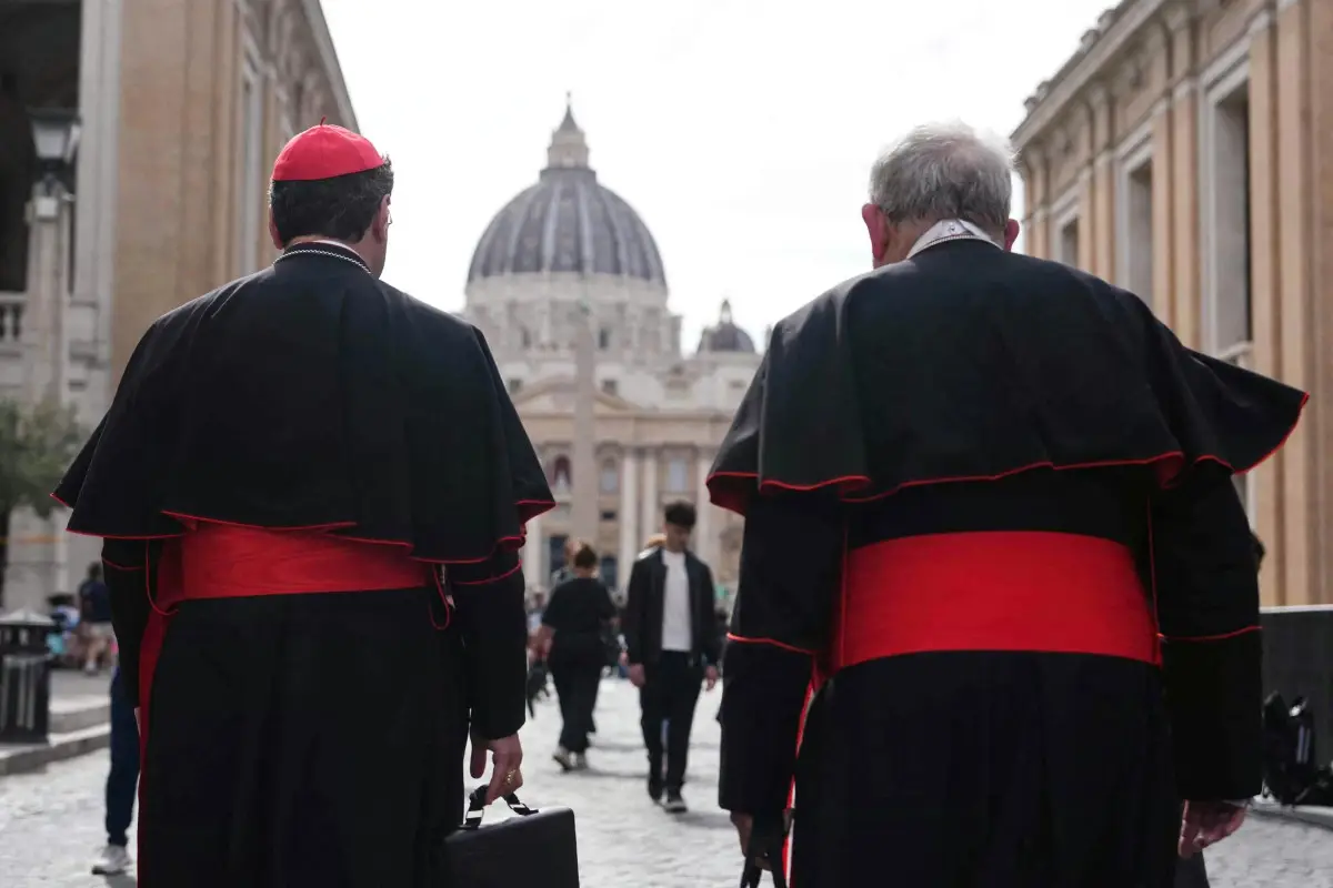 El cardenal canadiense Thomas Christopher Collins (R) y el cardenal canadiense Francis Leo caminan por la calle Via della Conciliazione cerca del Vaticano con la Basílica de San Pedro al fondo en Roma el 5 de mayo de 2025.