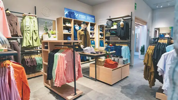 Una tienda de MAJA Sportsware en donde se muestran diferentes tipos de ropa especializada para actividades al aire libre, como pesca deportiva o senderismo.