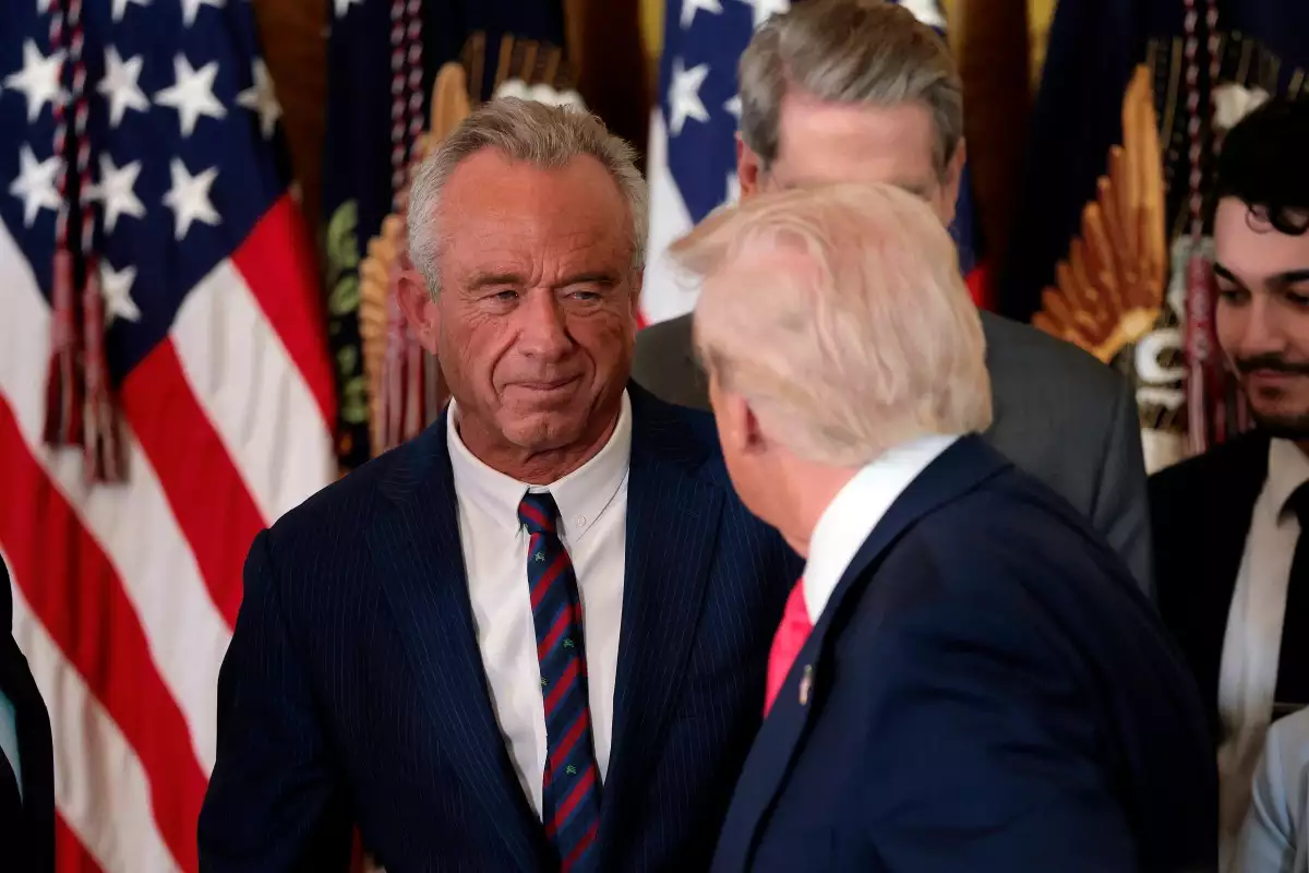 El presidente Donald Trump, estrecha la mano del Secretario de Salud y Servicios Humanos Robert F. Kennedy Jr. junto con el Secretario de Vivienda y Desarrollo Urbano Scott Turner (izquierda) después de que Trump firmara la orden ejecutiva "Fomentar el Futuro" en la Sala Este de la Casa Blanca el 13 de noviembre de 2025 en Washington, DC.