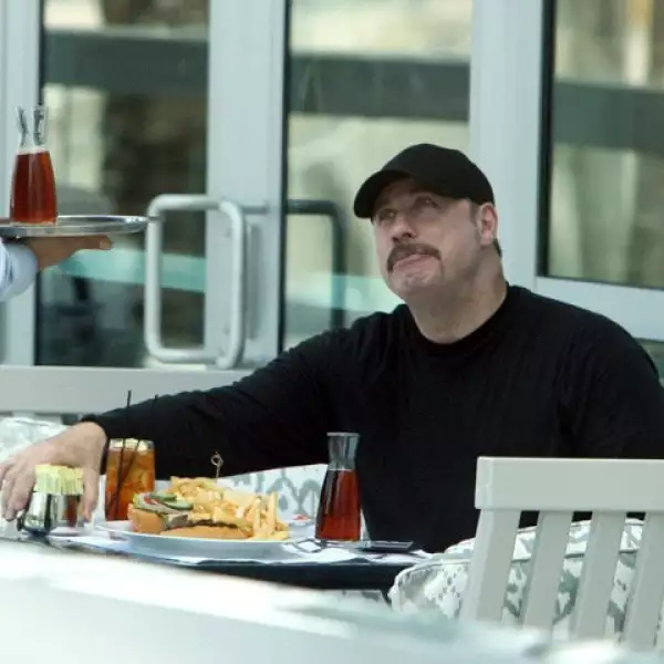 Tan pronto John Travolta bajó de su avión fue a un restaurante, donde pidió una enorme hamburguesa con papas fritas y refresco.