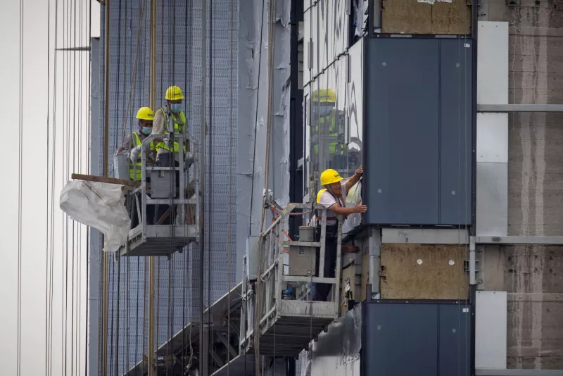 hombres trabajan en el sitio de construcción de un edificio de apartamentos en Beijing, China