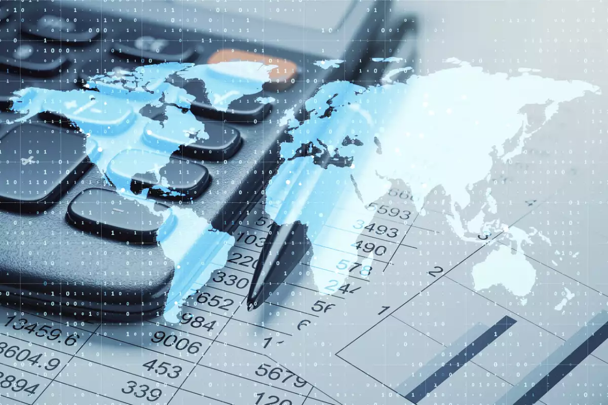 Calculator, pen, and world map overlay on financial data sheets, representing global business and digital accounting concepts.