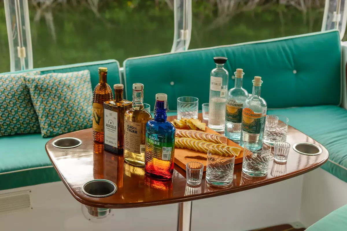 El sunset tasting es en un bote por los canales de Mayakobá donde desgustas mezcal Ojo de Tigre.