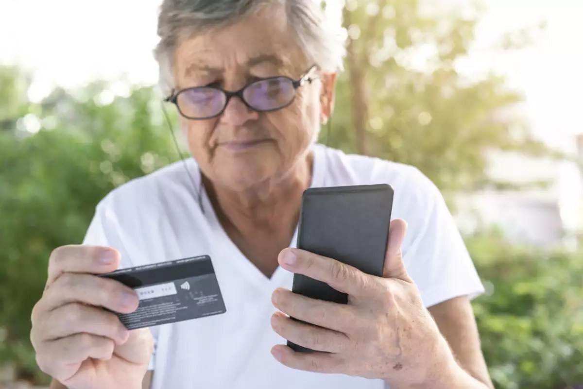 mujer viendo su celular con teléfono en mano 