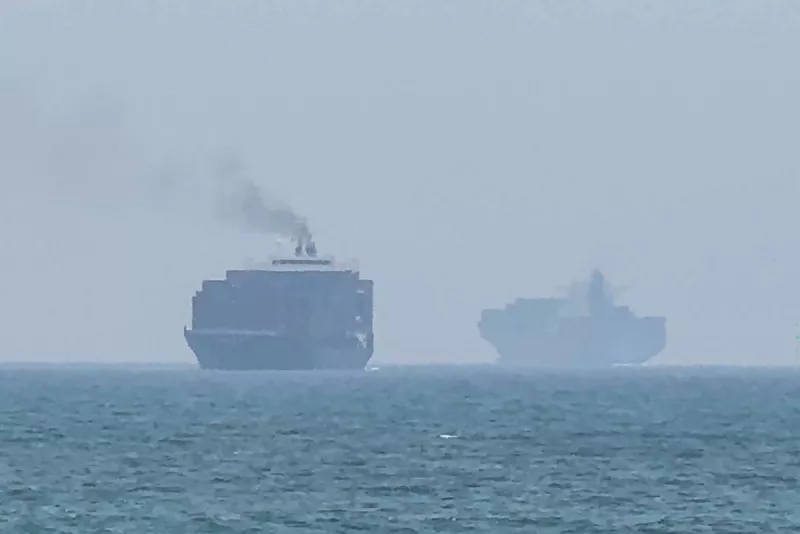 Esta toma de fotogramas tomada de las imágenes de vídeo de AFPTV del 12 de julio de 2026 muestra a los buques de carga anclados cerca del Estrecho de Ormuz, frente a la costa este de los Emiratos Árabes Unidos en Khor Fakkan