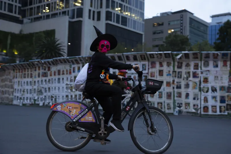 Ciclista posa sobre la Glorieta de los Desaparecidos durante el Paseo Nocturno de Día de Muertos 2026. 