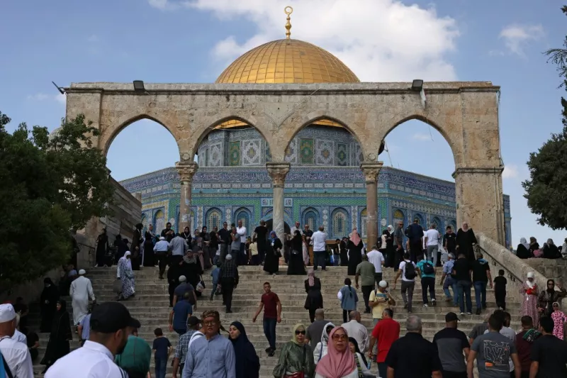 Los palestinos pasan por la Cúpula de la Roca en el complejo de la Mezquita de Al-Aqsa, el tercer sitio más sagrado del Islam, después de las oraciones del viernes en la Ciudad Vieja de Jerusalén el 6 de octubre de 2023.