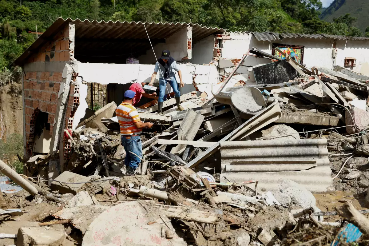 Los residentes recuperan sus pertenencias de una casa dañada por un deslizamiento de tierra que dejó varias víctimas y otras heridas, en Quetame, Colombia, el 18 de julio de 2023.