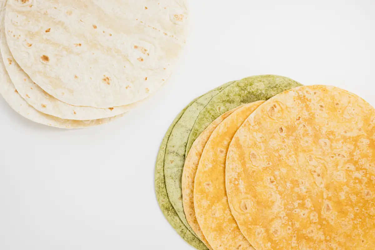 Spanish tomato, spinach flavored and plain wheat tortilla wraps on white background