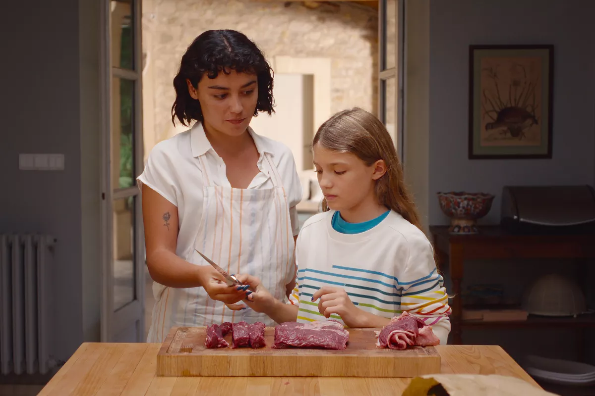 Foto de una escena de la película 'Delicia' de Netflix con Teodora dándole de comer carne cruda a la pequeña Alba. (Imagen principal del artículo "‘Delicia’: su reparto y de qué trata la película alemana de Netflix de la que todos hablan"). 