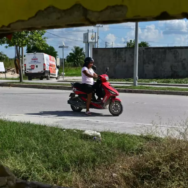 Una mujer pasa frente a una vivienda que comienza a ser demolida en Candelaria, Campeche, por estar cerca del derecho de vía del Tren Maya