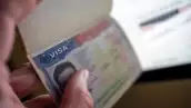 Unknown causian person holding passport with visa