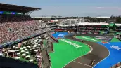 Vista panorámica del Autódromo Hermanos Rodríguez durante una carrera de Fórmula 1, con monoplazas en pista, gradas llenas y el Foro Sol al fondo.