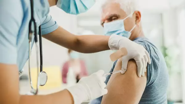 Una enfermera le da una vacuna a un hombre mayor debido a la pandemia de coronavirus.