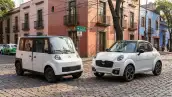 Olinia Uno y Zacua MX3 estacionados frente a frente en una calle de la Ciudad de México, rodeados de edificios y vehículos urbanos.